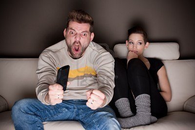9687914-goaaaaal-a-man-watching-football-while-his-girlfriend-is-sitting-besides-him-bored-showing-the-diffe